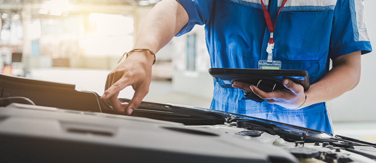 Seorang Automotive Technician sedang memeriksa sistem elektrikal mobil